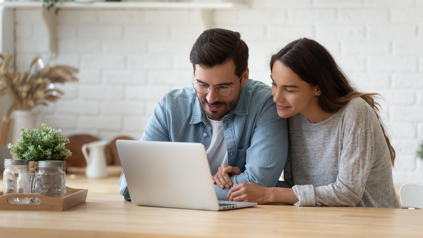 Couple sitting together looking at a laptop