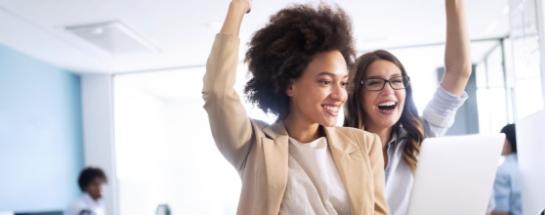 Women looking at a laptop and cheering